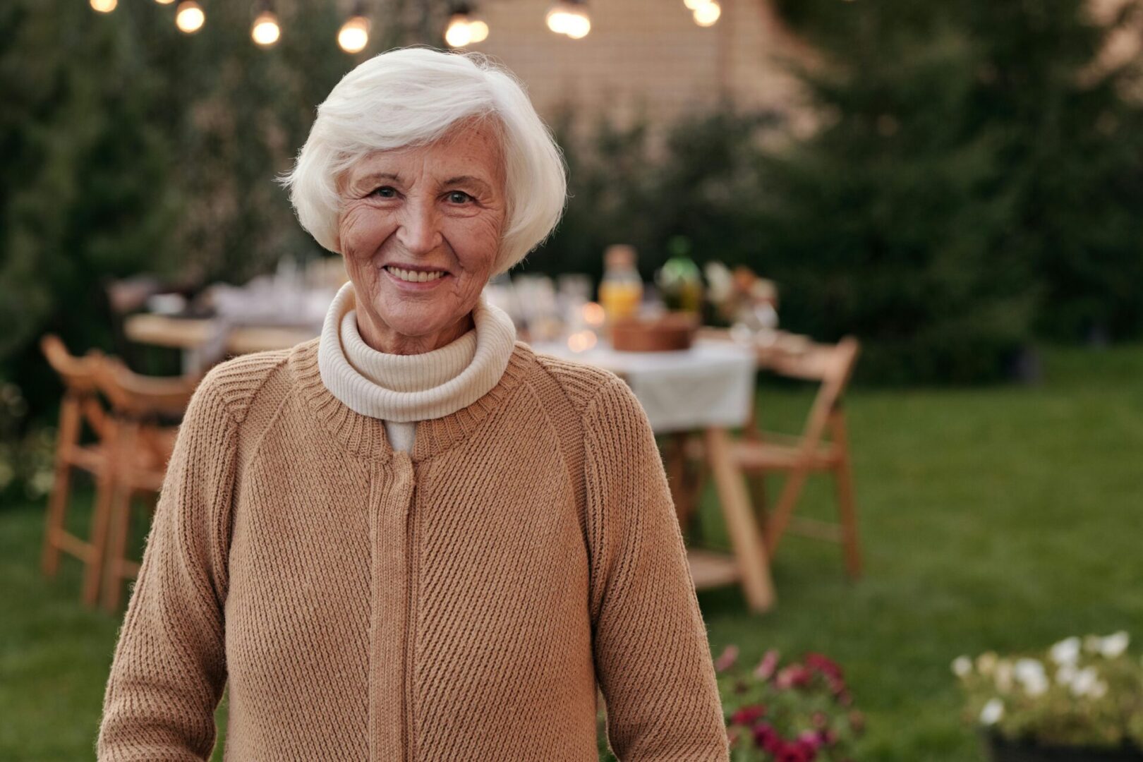 A woman standing in front of an outdoor table.