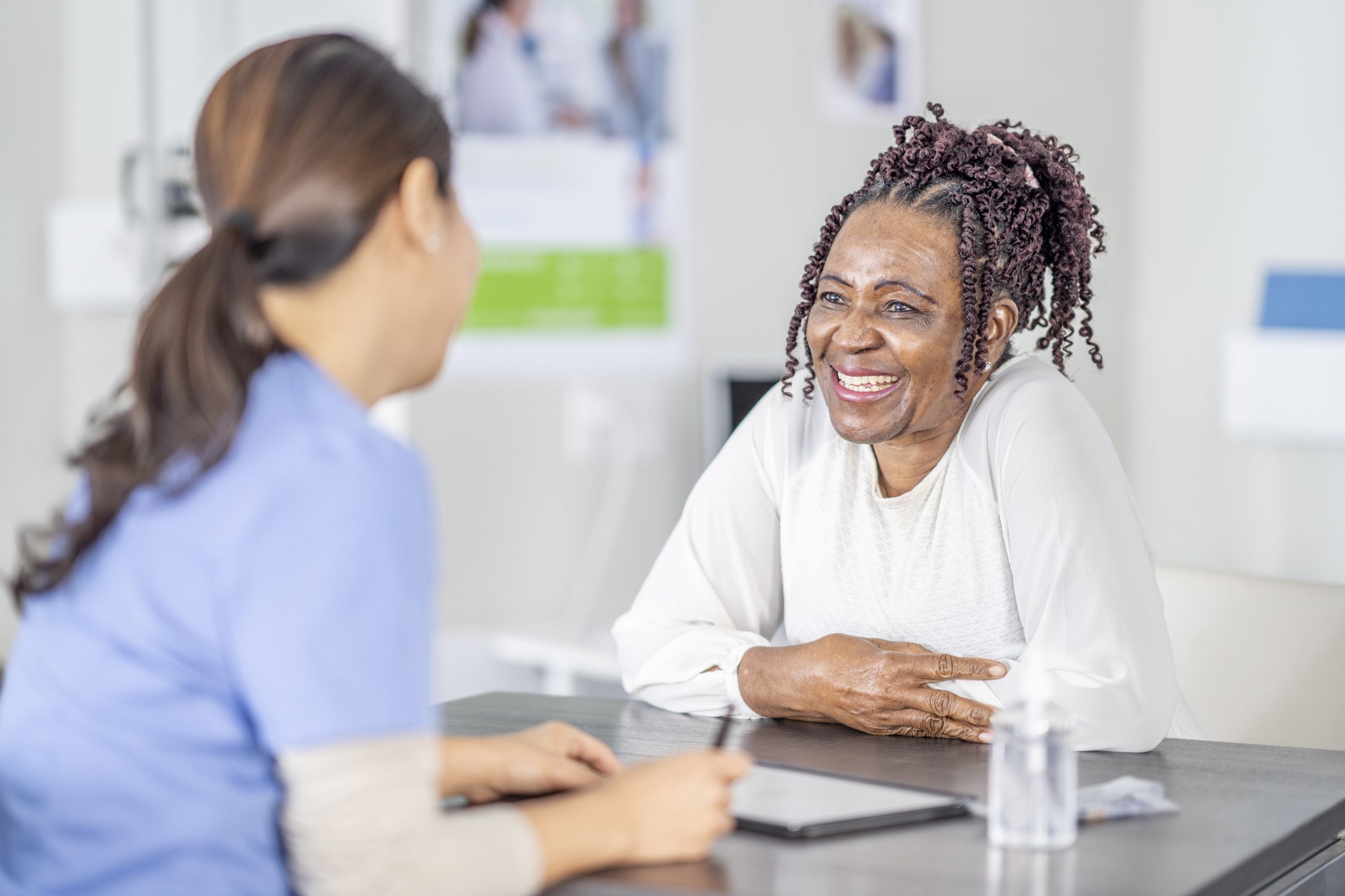 A healthcare provider discusses Medicare Advantage plans with a smiling senior woman in a welcoming office setting.