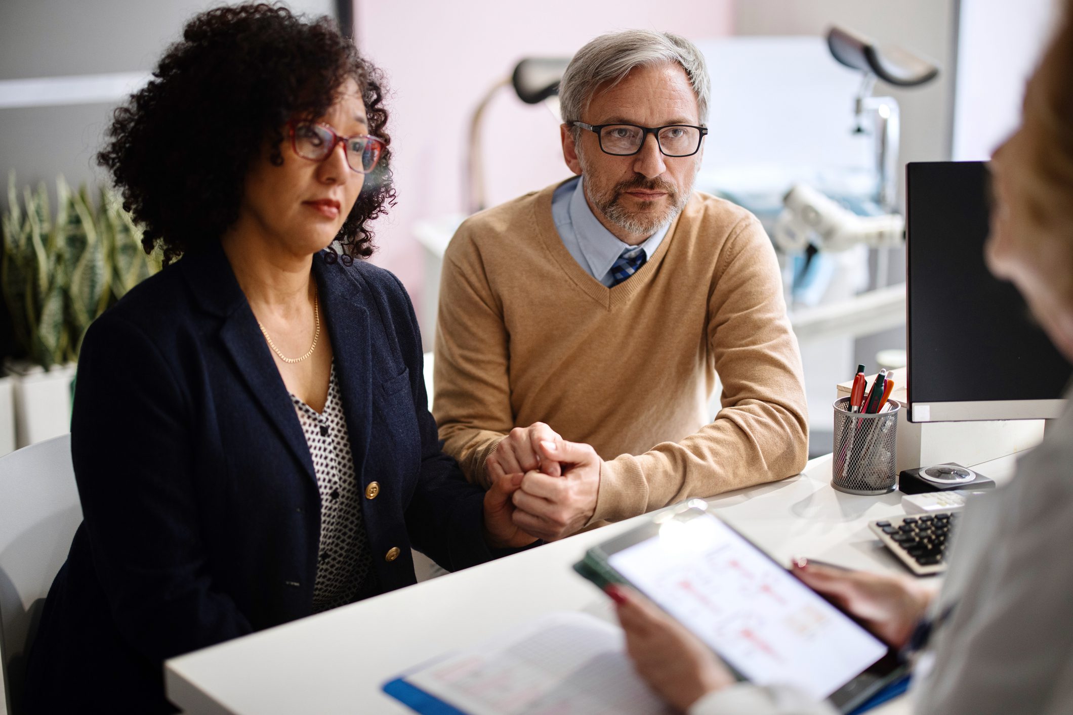 Couple holding hands during medical consultation