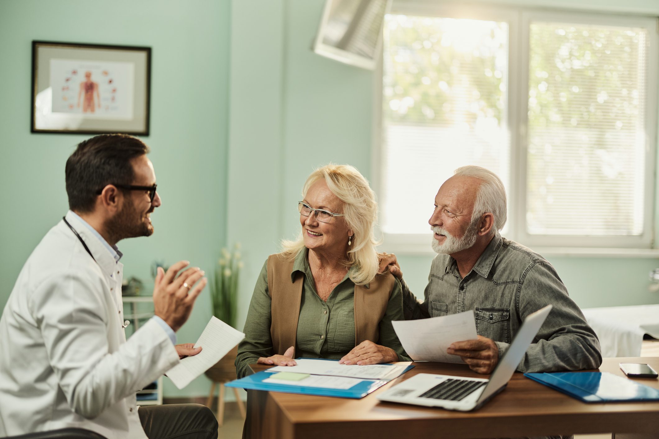 A doctor discusses Medicare Supplement Plans with an elderly couple in a bright, welcoming office.