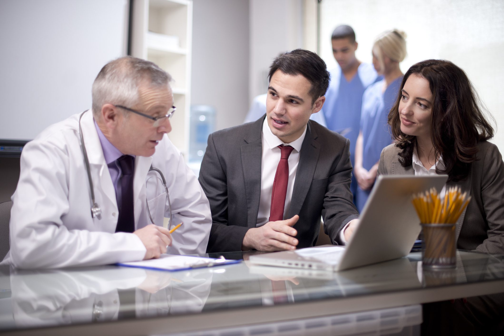 Doctor consulting with two professionals at desk