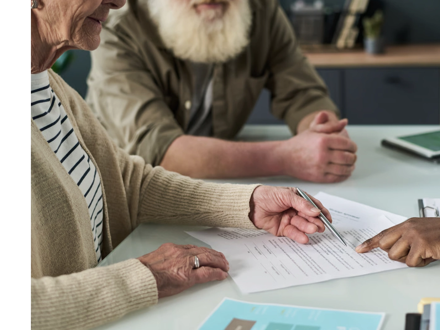 Senior couple signing paperwork with advisor