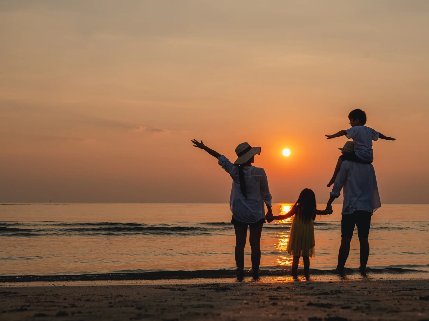 A family enjoys a sunset along New Jersey Coastline, demonstrating the importance of good health and which requires good health insurance coverage