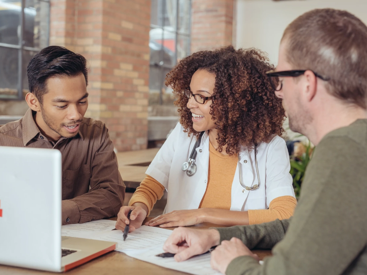 Doctor consulting two patients at a table