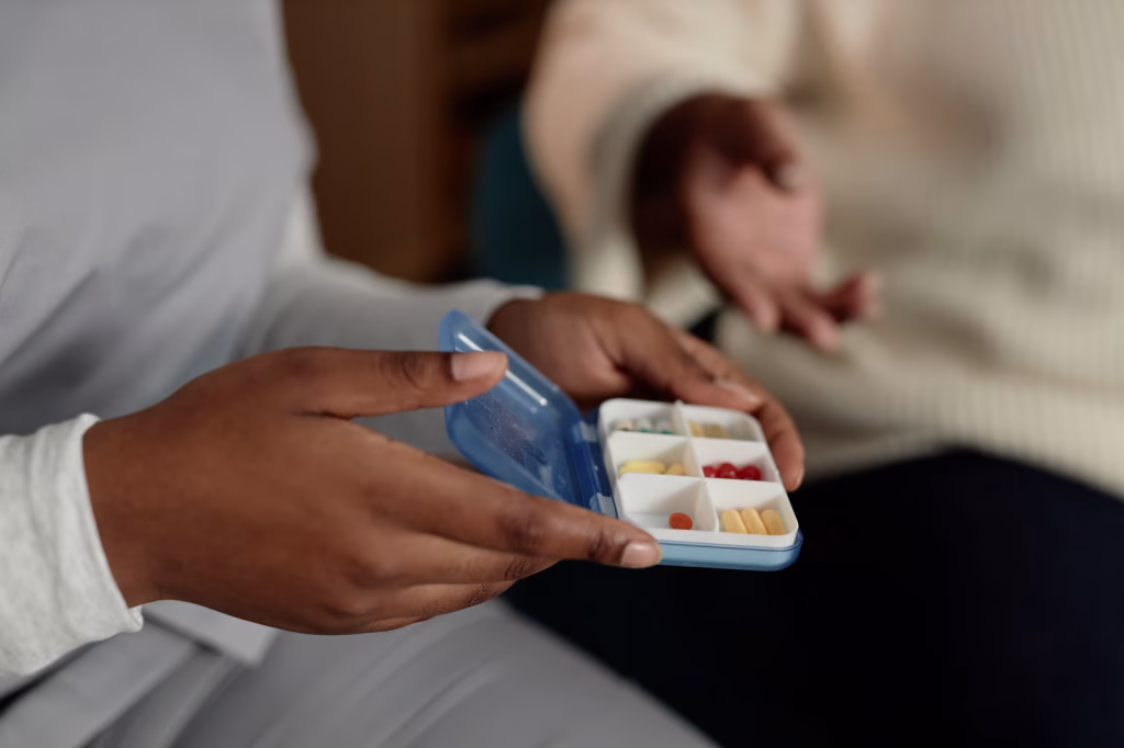 Person holding a pill organizer box.