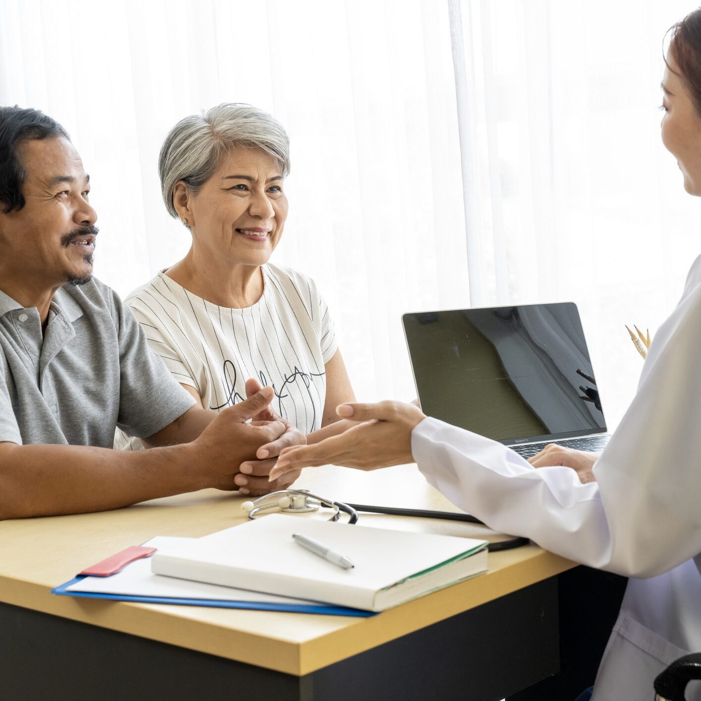 Smiling doctor consulting elderly couple